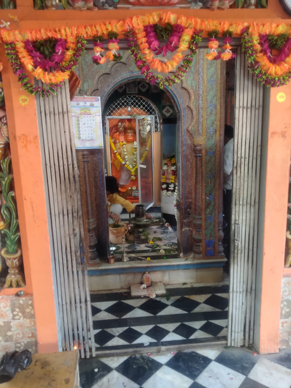 एक सजाया हुआ दरवाजा, जिसमें फूल और मालाएं लटकी हैं, जो सौंदर्य और उत्सव का अनुभव कराता है।